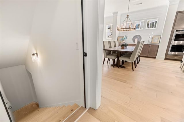 interior space featuring light wood-type flooring and a notable chandelier