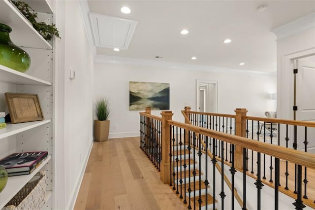 hallway with built in shelves, light wood-type flooring, and crown molding