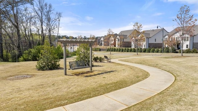 surrounding community with a pergola and a yard