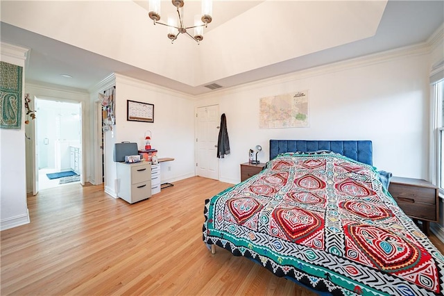 bedroom featuring a notable chandelier, baseboards, ornamental molding, light wood-type flooring, and a raised ceiling