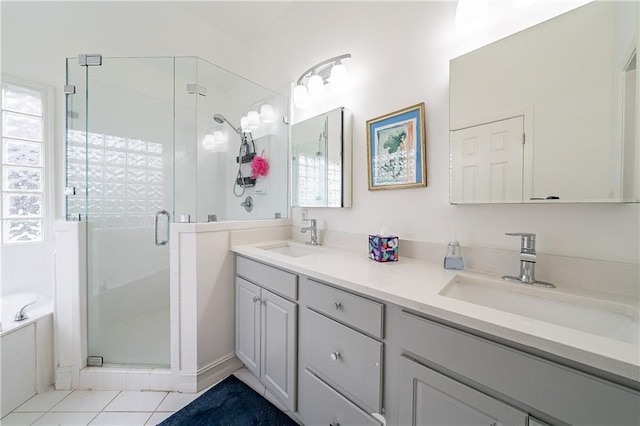 full bath featuring double vanity, a garden tub, a shower stall, and a sink