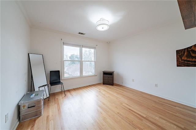 interior space with light wood-style flooring, visible vents, baseboards, and ornamental molding