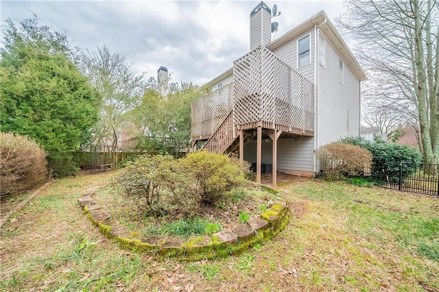 exterior space with a chimney, stairs, fence, and a wooden deck