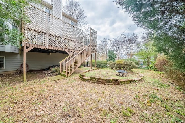 view of yard featuring stairway, a fire pit, and a wooden deck