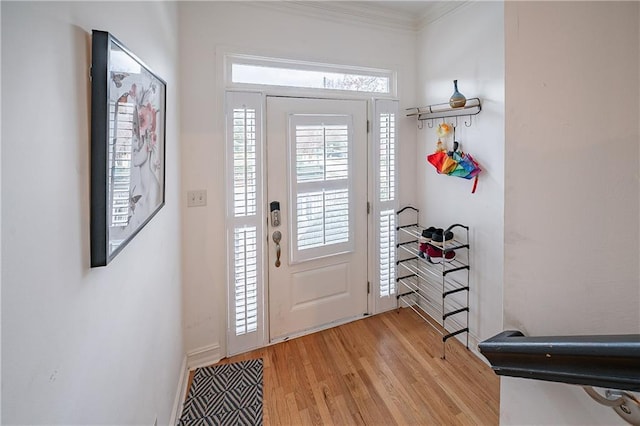 foyer with light wood finished floors and ornamental molding