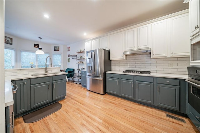 kitchen with stainless steel appliances, gray cabinets, white cabinets, and a sink