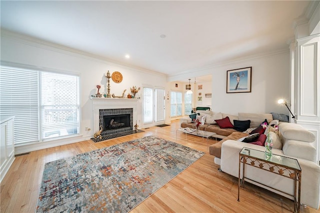 living room featuring a fireplace, crown molding, and wood finished floors