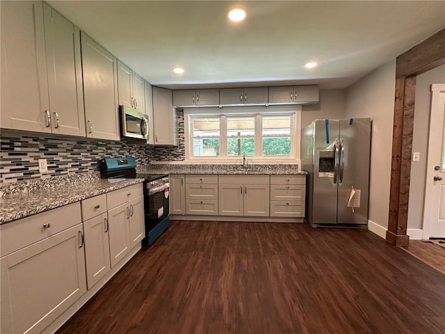 6538 N Sweetwater Rd, Lithia Springs, GA 30122 - kitchen with stainless steel appliances, dark wood finished floors, tasteful backsplash, a sink, and light stone countertops