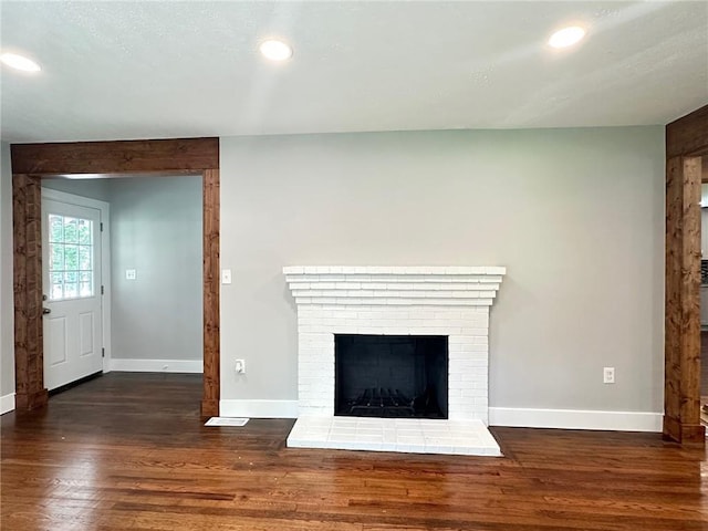 6538 N Sweetwater Rd, Lithia Springs, GA 30122 - unfurnished living room featuring wood finished floors, baseboards, recessed lighting, and a fireplace