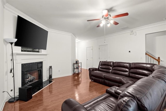 living room with a high end fireplace, hardwood / wood-style flooring, and ornamental molding