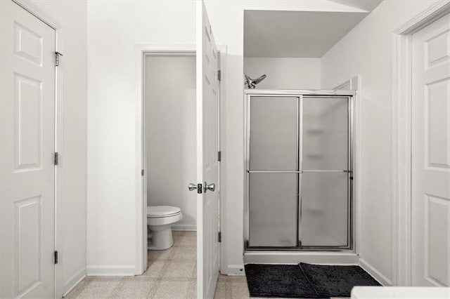 bathroom with a shower with shower door and toilet