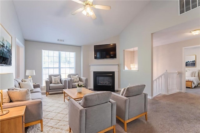 5033 Kens Ct, Stockbridge, GA 30281 - living area featuring lofted ceiling, ceiling fan, a glass covered fireplace, and light colored carpet