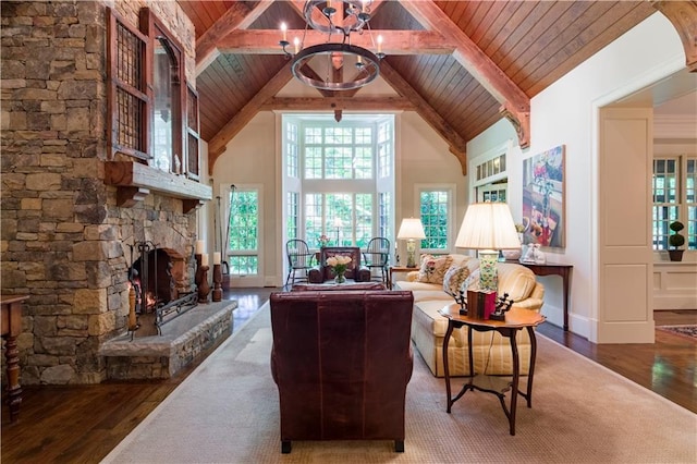 living room featuring a stone fireplace, a chandelier, hardwood / wood-style floors, and high vaulted ceiling