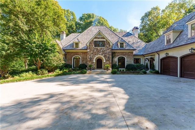 french country inspired facade featuring a garage