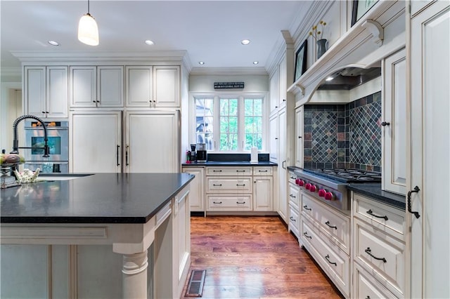 kitchen with sink, crown molding, backsplash, decorative light fixtures, and stainless steel gas stovetop