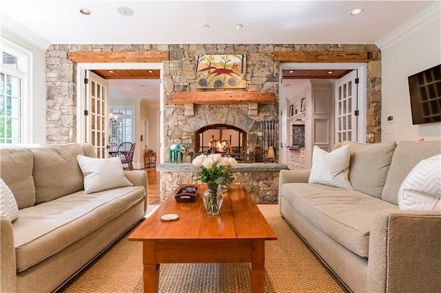 living room with crown molding, a fireplace, and light hardwood / wood-style flooring