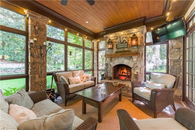 sunroom featuring a stone fireplace and wood ceiling