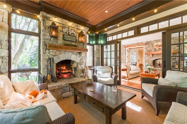 interior space with crown molding, a wealth of natural light, wooden ceiling, and a fireplace