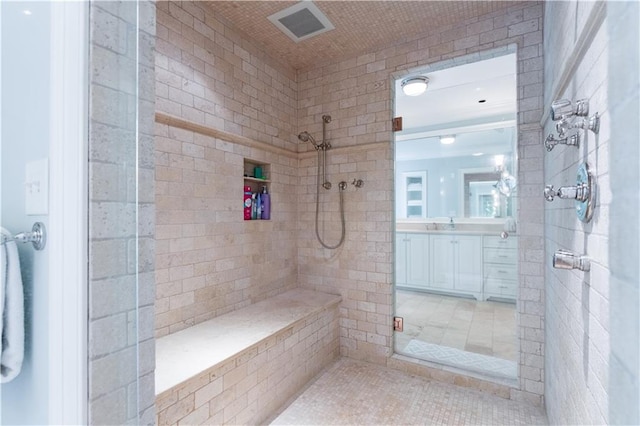 bathroom featuring a tile shower and tile patterned flooring