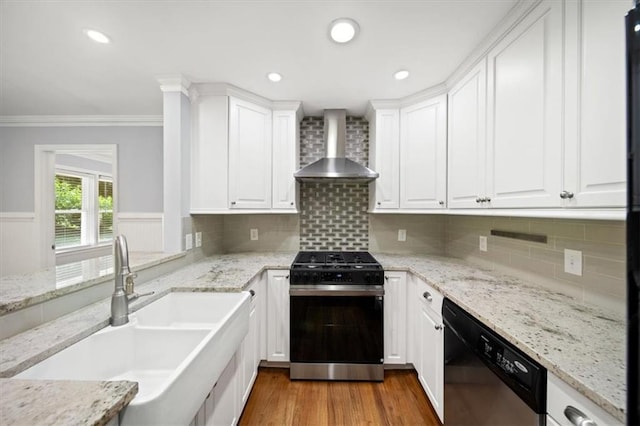 2100 Shady Ln, Tucker, GA 30084 - kitchen with gas range oven, wall chimney exhaust hood, stainless steel dishwasher, a sink, and light wood-style floors