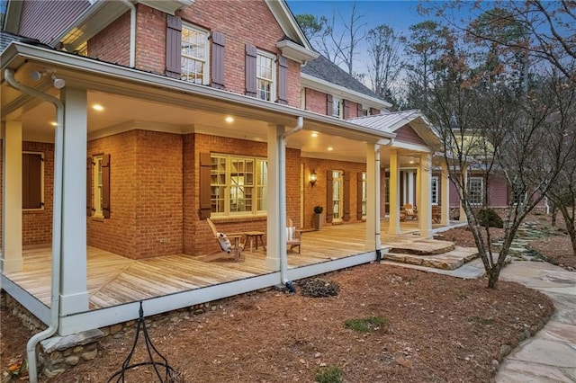 property exterior at dusk featuring covered porch