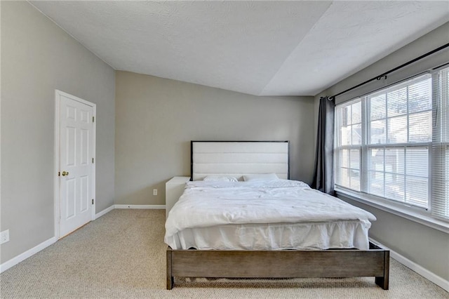 carpeted bedroom with lofted ceiling