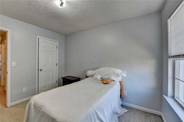 bedroom with a textured ceiling and light colored carpet