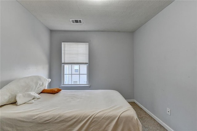 bedroom with a textured ceiling and carpet