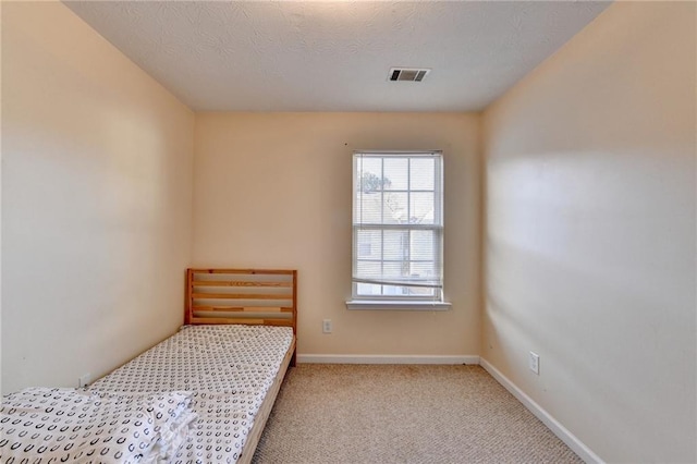 carpeted bedroom featuring a textured ceiling