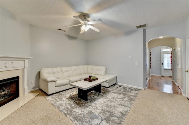 carpeted living room featuring a textured ceiling and ceiling fan