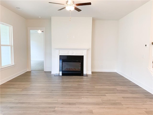 unfurnished living room featuring ceiling fan and light hardwood / wood-style flooring