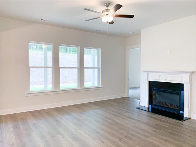 unfurnished living room with light hardwood / wood-style floors and ceiling fan