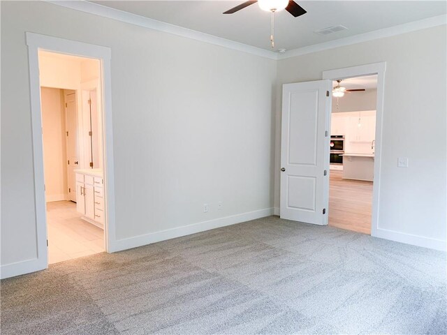 empty room with crown molding, ceiling fan, and light carpet