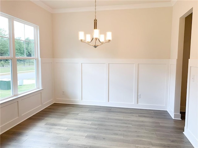 unfurnished dining area with light hardwood / wood-style flooring, crown molding, a chandelier, and a healthy amount of sunlight