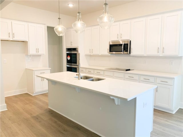 kitchen with white cabinetry, appliances with stainless steel finishes, and hanging light fixtures