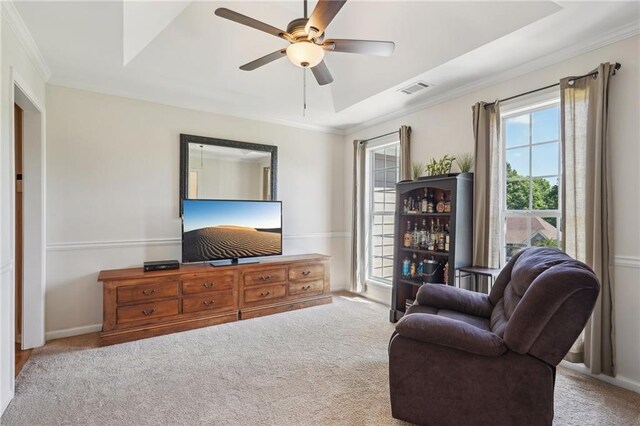carpeted living room featuring a ceiling fan, ornamental molding, and baseboards