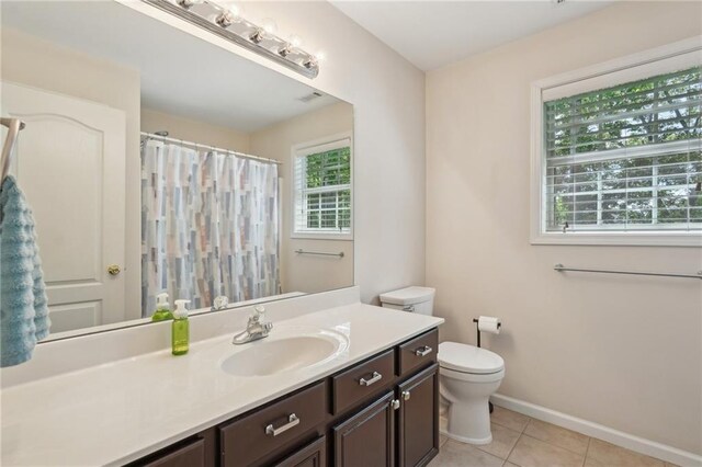 full bathroom featuring toilet, tile patterned flooring, vanity, baseboards, and a shower with shower curtain