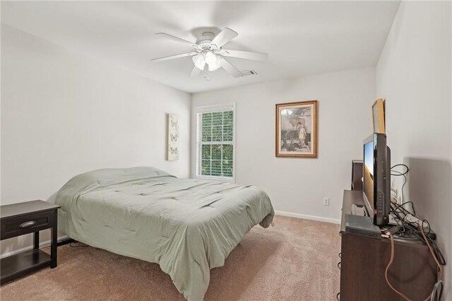 bedroom featuring light colored carpet, baseboards, and ceiling fan