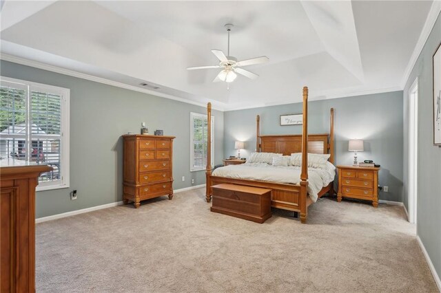 bedroom featuring a tray ceiling, light colored carpet, baseboards, crown molding, and ceiling fan