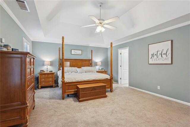 bedroom with light colored carpet, ornamental molding, a tray ceiling, baseboards, and ceiling fan
