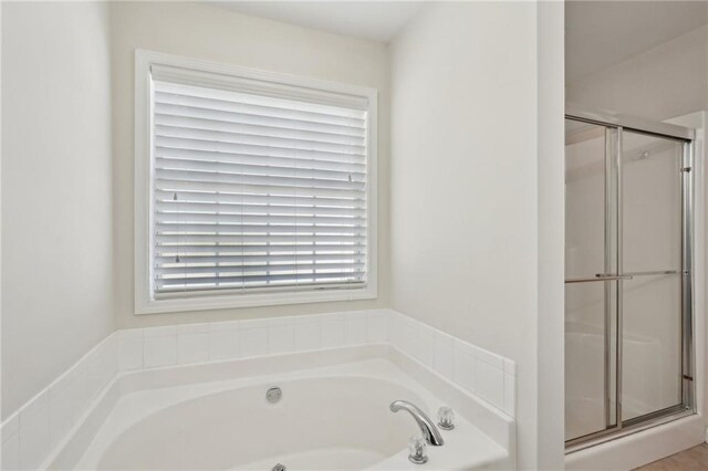 full bath with a stall shower and a garden tub
