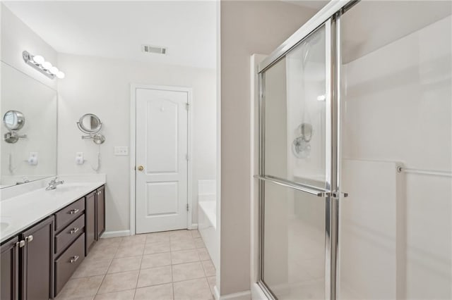 full bath with a shower stall, tile patterned floors, double vanity, a bath, and baseboards