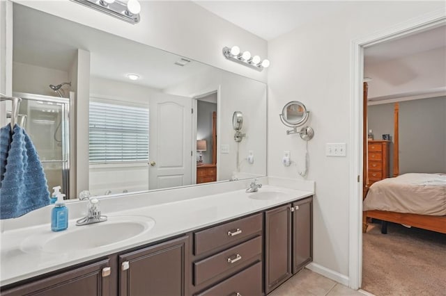 ensuite bathroom with an enclosed shower, double vanity, tile patterned floors, and baseboards