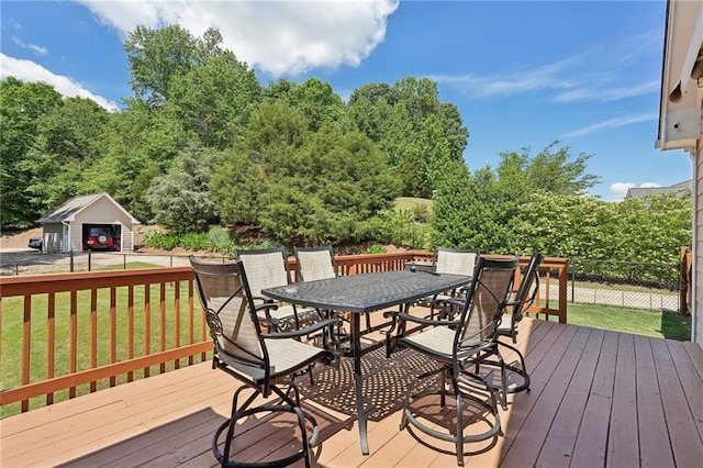 wooden deck featuring outdoor dining space and a detached garage