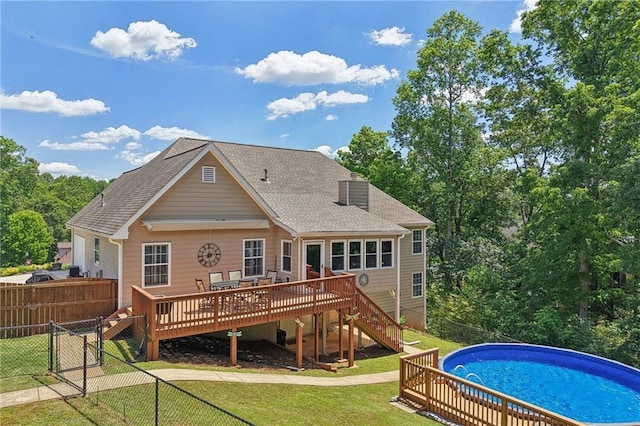 rear view of house featuring a wooden deck, stairs, a shingled roof, and a gate