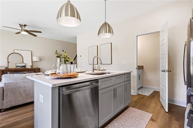 kitchen featuring dishwasher, gray cabinets, a sink, light countertops, and a ceiling fan