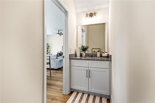 bathroom with wood finished floors, vanity, and ceiling fan