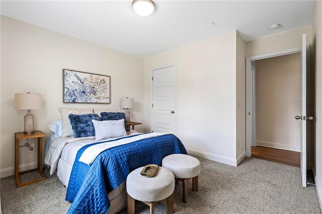carpeted bedroom featuring baseboards and a closet