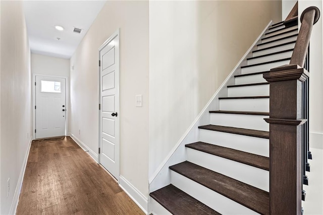 stairs featuring wood finished floors, baseboards, and recessed lighting