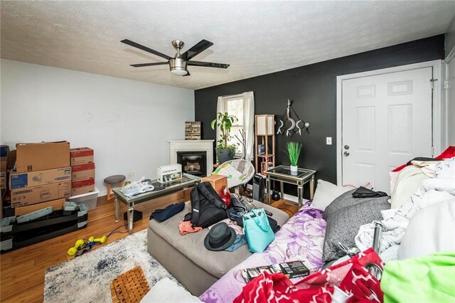 57 George Byrom Rd, Newnan, GA 30263 - living area with a ceiling fan, a glass covered fireplace, wood finished floors, and a textured ceiling